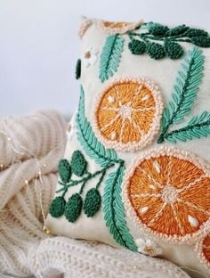 an embroidered pillow with oranges on it