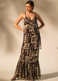 White and black abstract printed cutout maxi dress with a tie back and multicolored tassels on the sides. V Neck Gown, Dress With Cutouts, Abstract Print Dress, Printed Gowns, Cutout Maxi Dress, Georgette Dress, Sleeveless Long Dress, Maxi Styles, White Gowns