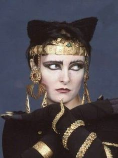 a woman with black and gold makeup is dressed in costume