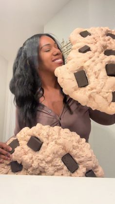 a woman holding two cookies in front of her face