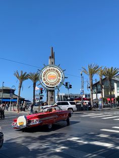 an old car driving down the street in front of a sign