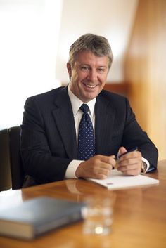 a man sitting at a table signing papers