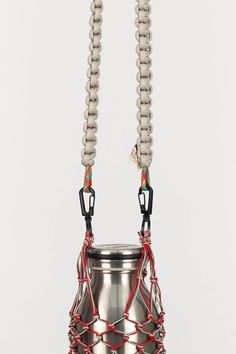 a metal bucket with two strings attached to it's sides and an object in the middle