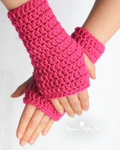 a woman's hand wearing pink crocheted fingerless gloves