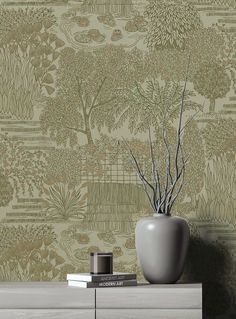 a vase sitting on top of a dresser next to a wallpaper covered in trees