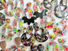 many different colored and shaped earrings on a white surface