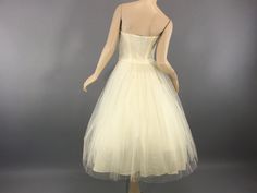 "A beautiful vintage 1950' dance dress - ivory strapless fit and flare - sweetheart neckline - boned corset bodice - side metal zipper - under petticoat - tea length skirt - ivory taffeta underskirt - 2 net overskirts - accordion pleated layers sprinkled with Rhinestones - perfect for formal,wedding or reception dress era - 1950's color - ivory material - tulle net taffeta rhinestones label - Dance Original by Fred Perlberg condition - excellent clean & ready to wear measurements - fits like Wedding Tea-length Corset Dress With Fitted Bodice, Wedding Corset Dress With Fitted Bodice In Tea Length, Retro Wedding Dress With Sweetheart Neckline, Vintage Dress With Boned Bodice And Sweetheart Neckline, Vintage Dress With Corset Back And Sweetheart Neckline, Vintage Corset Dress With Boned Bodice And Sweetheart Neckline, Cream Wedding Corset Dress With Boned Bodice, Vintage Sleeveless Corset Dress With Lined Bodice, Vintage Dress With Sweetheart Neckline For Vintage Events