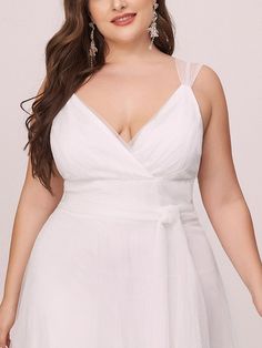 a woman in a white dress posing for the camera with her hands on her hips