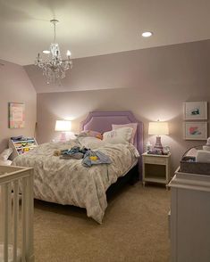 a bed room with a neatly made bed and a chandelier hanging from the ceiling