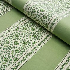 the green and white fabric has an intricate design on it