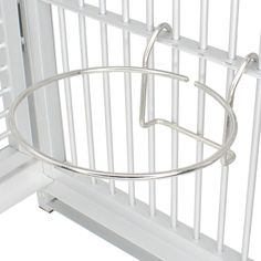 a white bird cage with metal bars on the top and bottom, hanging from it's side