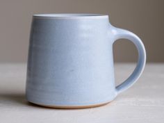 a blue coffee mug sitting on top of a table