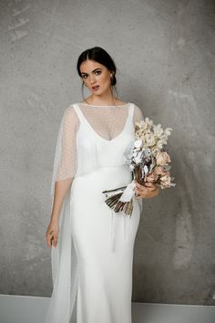 a woman in a white dress holding flowers