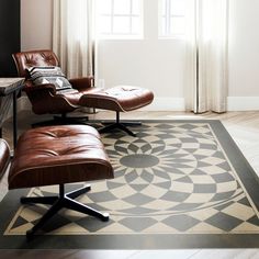 a chair and ottoman in front of a window with an area rug on the floor