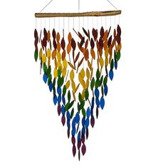 a multicolored wind chime hanging from a wooden stick with leaves on it