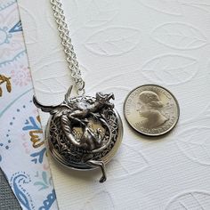 Gargoyle Dragon Guardian Protection Locket ☻Locket ~ Round Silver ~ With Bronze Bunny ~ With Flower ~ See Photos for size comparison against American quarter Chain: ~ Silver Plated YOU CHOOSE YOUR CHAIN LENGTH during checkout ☻More Lockets Here: https://www.etsy.com/shop/FashionCrashJewelry/search?search_query=lockets&order=date_desc&view_type=gallery&ref=shop_search ☻Link to The ENTIRE SHOP: https://www.etsy.com/shop/FashionCrashJewelry?ref=shopsection_shophome_leftnav&ga_search Antique Dragon Design Jewelry Gift, Antique Dragon Design Jewelry For Gift, Vintage Dragon Design Jewelry For Gifts, Vintage Dragon Design Jewelry Gift, Vintage Jewelry With Dragon Design Gift, Vintage Jewelry With Dragon Design For Gift, Antique Finish Pewter Jewelry As Gift, Adjustable Antique Silver Jewelry, Antique Silver Adjustable Locket Jewelry