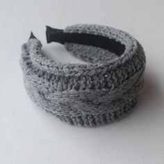 there is a knitted headband with a black handle on the top of it