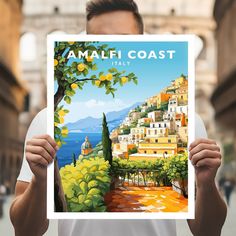 a man holding up a poster with the words amalfi coast italy on it