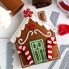 a gingerbread house ornament with candy canes on it and other decorations