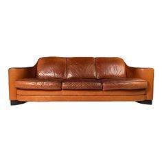 a brown leather couch sitting on top of a white floor next to a wooden frame