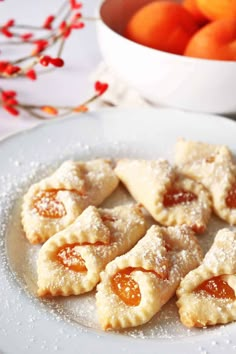 small pastries on a white plate with oranges in the background