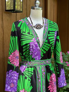 Thank You If You Favored One of My Items! You Will Receive 10% Off an Item of Your Choice, Unless It Is On Sale, Code17. Thank You. LOVELY 70's FLORAL MAXI DRESS/Floral Dresses/Floral Maxis/70's Maxi Dress/70's Dresses/Parkshirt Original Dress/Mint Condition This is a Lovely Circa 70's Floral Maxi Dress.  It has a V Neck, Long Sleeves, and is Maxi in Length.  It is Styled Similarly to an EMILIO PUCCI from the 60's with the Borders Around the Neck, the Waist, and down the Middle Front.  The Flowers are Huge and done in Pink and Purple.  It is Highlighted with Green Leaves. Measurements - Bust - 40"                               Shoulder width - 14.5"                               Sleeve length - 21.5"                               Waist - 29"                               Hips - 38" Vintage V-neck Dress With Retro Print, 1970s Green Floral Print Dress, 1970s Style Green Floral Print Dress, 70s Inspired Long Sleeve Floral Print Dresses, Maxi Dress Floral, 70s Maxi Dress, Dress Mint, Dresses Floral, 70s Dress