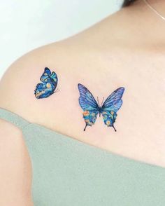 two blue butterflies on the back of a woman's shoulder