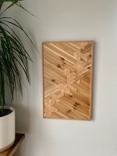 a potted plant sitting on top of a wooden shelf next to a wall plaque