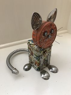 a mouse made out of tin cans and spoons