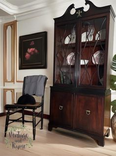 a chair sitting in front of a wooden cabinet with glass doors on the top and bottom