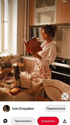 a woman standing in a kitchen reading a book