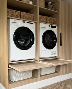 two washers and dryer sitting on shelves in a laundry room