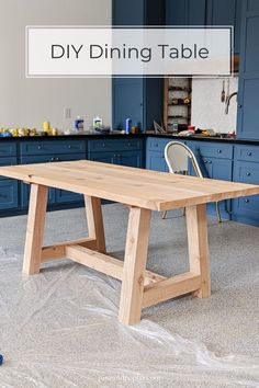 a wooden table sitting in the middle of a kitchen with blue cabinets and counter tops