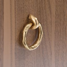 a close up of a gold ring on a wooden surface