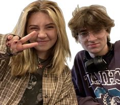 two people posing for the camera with their fingers up