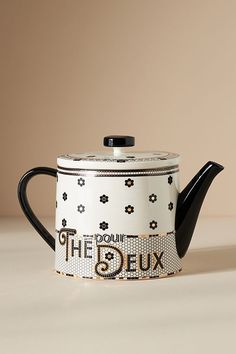 a black and white tea pot sitting on top of a table