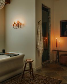 a bath room with a large tub and candles