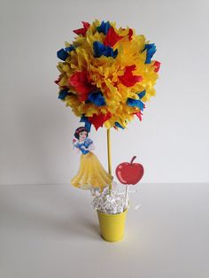 a flower pot with paper flowers in it and an apple on the top that has been made to look like a pinwheel