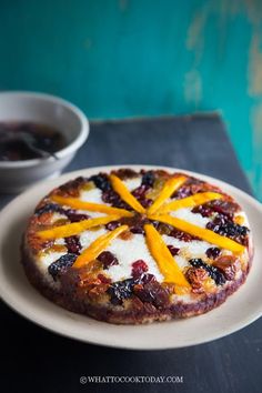 a small pizza on a white plate next to a cup of tea