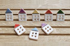 small ceramic houses and buttons on a wooden surface