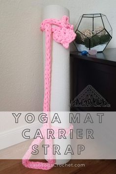 the yoga mat carrier strap is attached to a white pole with pink yarn on it