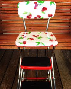 a red and white chair with cherries on it