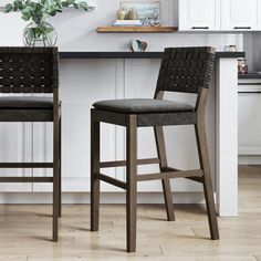 two black bar stools sitting in front of a kitchen counter