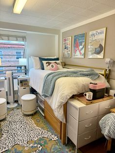 a bed room with a neatly made bed next to a desk and chair in front of a window