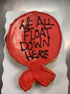 a red cake with black writing on it that says we all float down here,