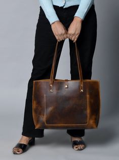 Step out in style with our handcrafted Buffalo Terry Tote. Made from luxurious Buffalo leather, this plain tote boasts a modern look and finish, perfect for your daily needs. Elevate any outfit with this sophisticated and exclusive accessory. Coffee Brown color Handcrafted & made of buffalo leather Top Handle and inside pocket Lightweight & durable leather Size in Inch 15W x 11H x 4 D Inch Size in Cm 38.1W x 27.94H x 10.16D Cm Luxury Bags With Waxed Finish For Everyday Use, Luxury Waxed Finish Shoulder Bag For Everyday, Classic Distressed Brown Bag For Everyday Use, Modern Brown Shoulder Bag With Waxed Finish, Modern Brown Bags With Waxed Finish, Elegant Brown Bags With Waxed Finish, Luxury Oiled Leather Everyday Bag, Luxury Everyday Oiled Leather Bag, Classic Tote Shoulder Bag With Waxed Finish