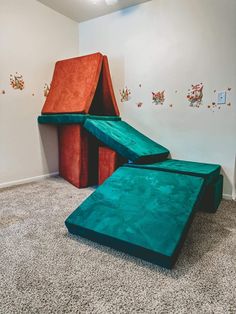 two children's play structures in the corner of a room with carpeted floor