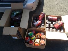 two boxes filled with drinks sitting next to a car