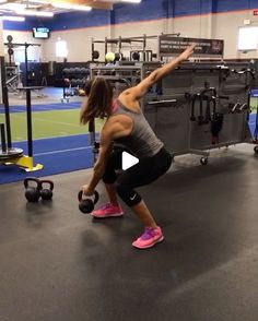 a woman is doing squats with kettles in a gym