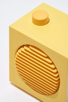 a yellow object with a round hole in the center on a white surface, it appears to be made out of cardboard